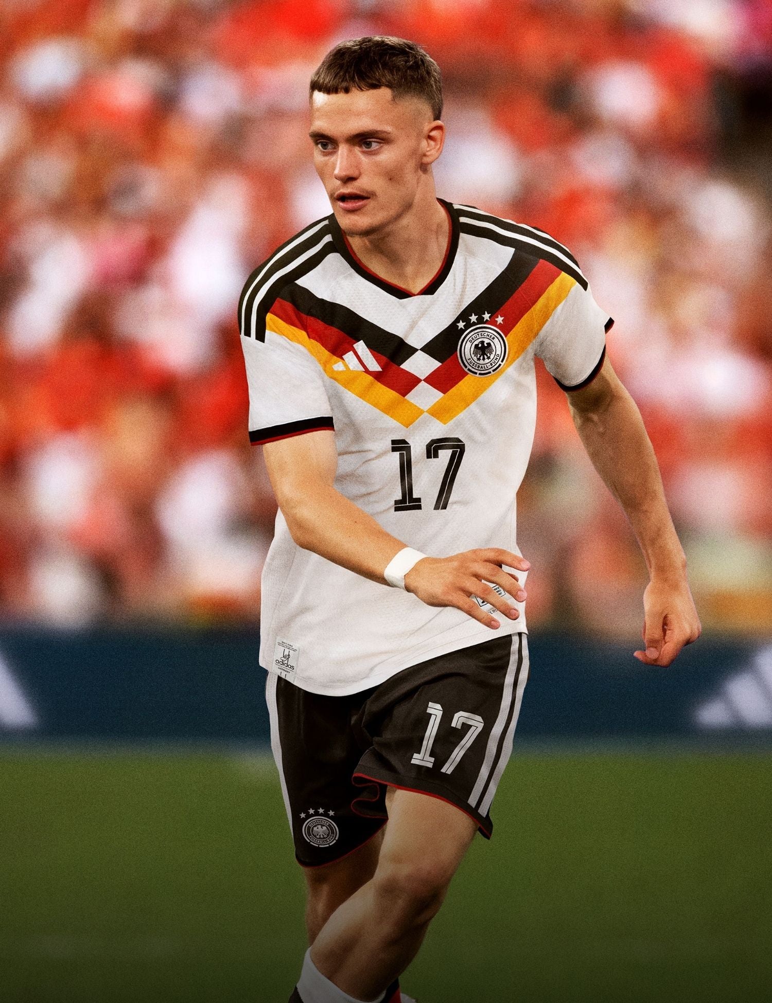 Soccer player in a Germany jersey with number 17 on a blurred stadium background