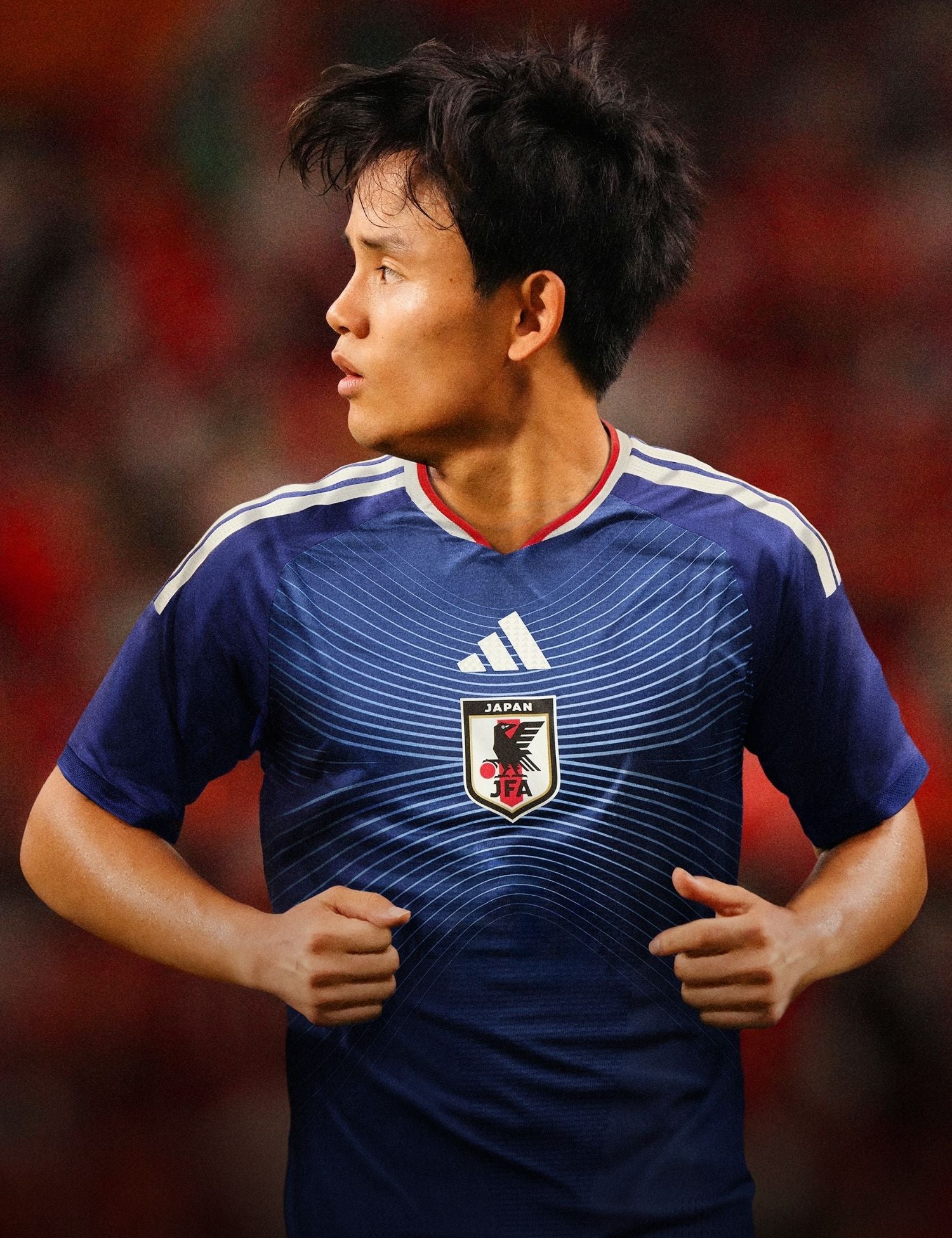 Soccer player wearing a Japan jersey with a logo on a blurred background